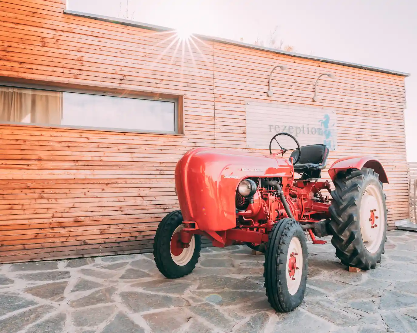 Red tractor in front of the reception at Gut Hügle