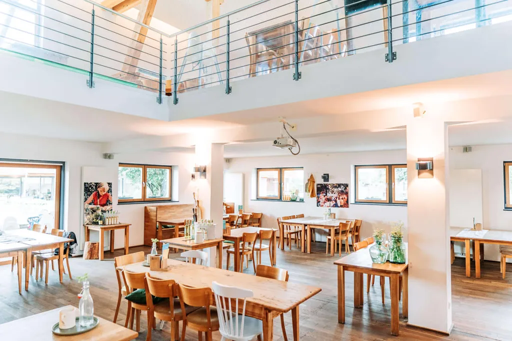 Bright restaurant room with wooden tables at Gut Hügle